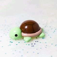 a small turtle figurine sitting on top of a white tablecloth covered floor