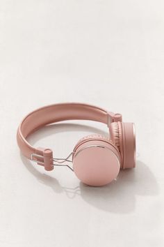 a pair of pink headphones sitting on top of a white table next to each other