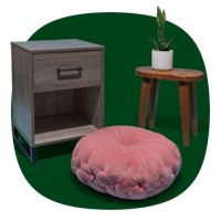 a small table with a pink pillow next to an end table and a potted plant