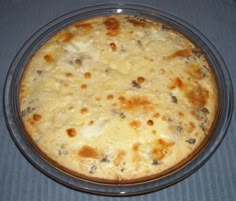 a casserole dish with cheese and meat in it on a blue table cloth