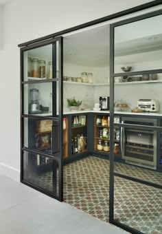 an open kitchen with glass doors and shelves