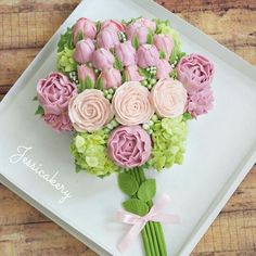 a bouquet of pink and green flowers sitting on top of a white plate