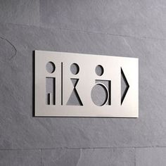 a stainless steel sign on the side of a wall with arrows pointing in different directions