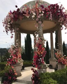 a gazebo covered in lots of pink and white flowers