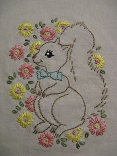 an embroidered bunny with flowers around it