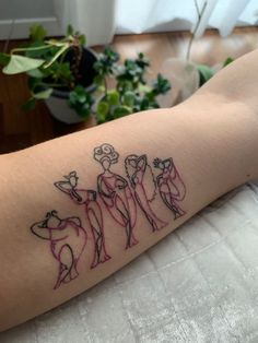 a person with a tattoo on their arm that has three dogs and flowers in it