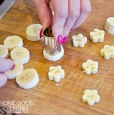 a person cutting bananas on top of a wooden table