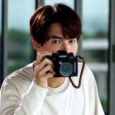 a young man holding up a camera to his face