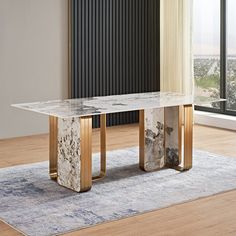 a marble dining table with gold legs in front of a window and rug on the floor