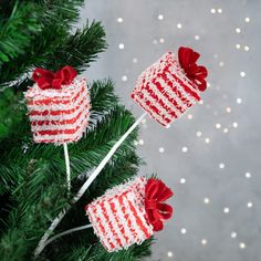 two red and white knitted christmas gifts hanging from a tree