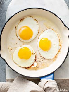 three fried eggs in a skillet on a counter