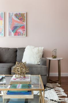 a living room filled with furniture and paintings on the wall above it's coffee table