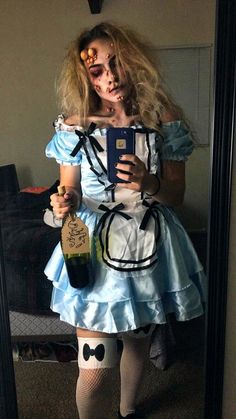 a woman dressed up as alice from the movie alice and the wonderland tea party holding a bottle