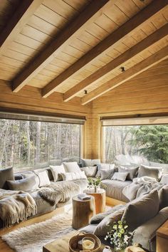 a living room filled with lots of furniture next to a large window covered in wood