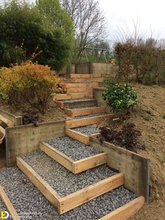 wooden steps leading up to the top of a hill with gravel and rocks in between them