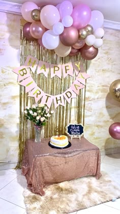 a birthday cake on a table with balloons and streamers