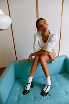 a woman sitting on top of a blue couch