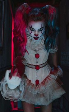 a woman dressed as a creepy clown with blue hair and makeup