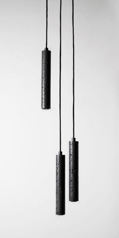 three black lights hanging from the ceiling in an empty room with white walls and flooring