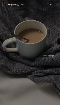 a cup of coffee sitting on top of a blanket