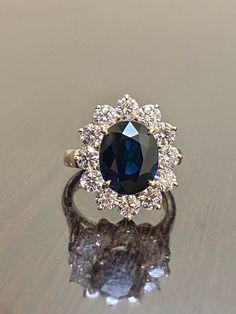 DeKara Designs Clearance Metal- 14K Yellow Gold, .583. Stones- Genuine Australian Oval Blue Sapphire 3.60-3.80 Carats, 12 Round Diamonds H-I Color SI1 Clarity, 1.50 Carats. Size- 3-12 Handmade 14K Yellow Gold Sapphire and Diamond Ring. This ring is inspired by Princess Diana and the Art Deco era with an enticing Australian fiery oval shaped midnight blue sapphire. The sapphire is professionally set in between four prongs. The sapphire has a halo of prong set 12 round diamonds surrounding them wh Diana Engagement Ring, Sapphire Halo Engagement Ring, Diana Ring, Blue Sapphire Engagement Ring, Diamond Princess, Expensive Jewelry Luxury, Vintage Sapphire, Sapphire Engagement Ring Blue, Etsy Wedding Rings