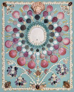 an intricately decorated wall hanging with seashells and shells on blue background,