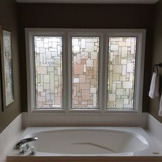 a bath tub sitting next to a window in a bathroom