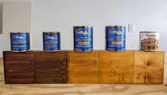 five cans of canned food on top of a wooden block