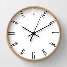 a white clock with black hands and numbers on the face is seen in this image