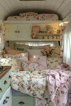 a bedroom with floral bedspread and pillows in the bed area, next to a window