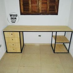 an empty room with a wooden desk and two drawers on the floor next to a window