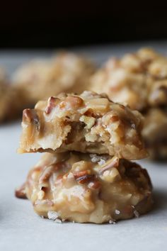 two cookies stacked on top of each other with pecans in the middle and one half eaten