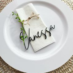 a white plate topped with a piece of paper next to a napkin on top of it