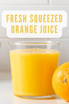 fresh squeezed orange juice in a glass next to an orange on a counter with the words, fresh squeezed orange juice