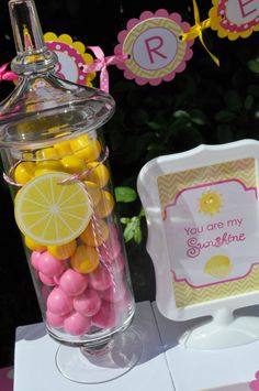 there is a glass jar filled with candies and lemons next to a sign that says you are my sunshine