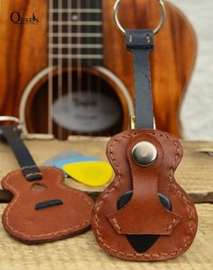 a guitar case and keychain are sitting next to each other on a table