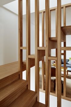 the interior of a house with wooden stairs and walls that are cut in half to make it look like an open airy space