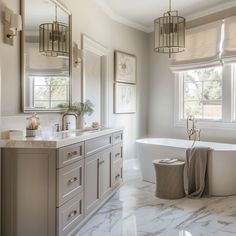 a bathroom with marble flooring and white bathtub next to double sinks, two mirrors on the wall