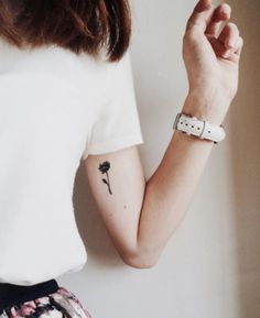 a woman with a small flower tattoo on her left arm, and the caption in spanish