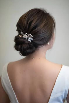 a woman with her back to the camera wearing a white dress and a hair comb