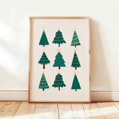 a wooden frame with christmas trees on it in front of a white wall and wood floor