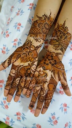 two hands with henna designs on them