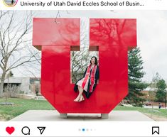 a woman sitting in the middle of a large red letter that says university of utah david eccless school of business