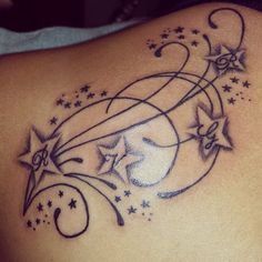 the back of a woman's shoulder with stars and swirls on her left side