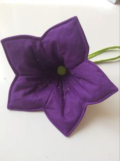 a purple flower sitting on top of a white table