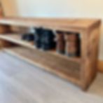 a wooden shelf sitting on top of a carpeted floor next to a white wall