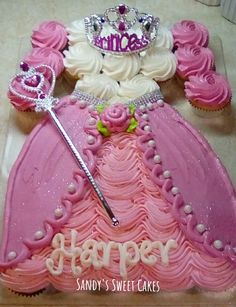 a princess dress cake with cupcakes in the background