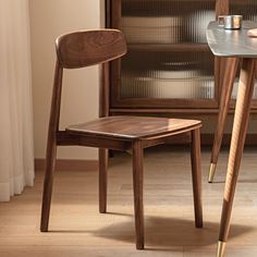 a wooden chair sitting next to a glass table