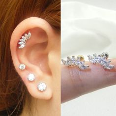 a woman's left ear has three different types of piercings on it