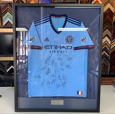 a signed shirt is displayed in a glass case